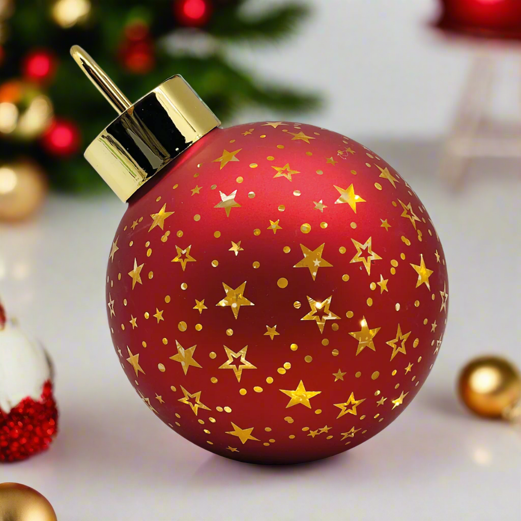 Red Christmas ornament with gold stars and a gold cap on a white background