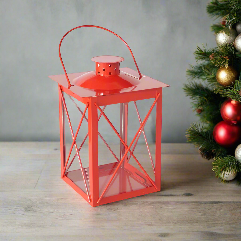 Red metal lantern with a clear glass front on a white background