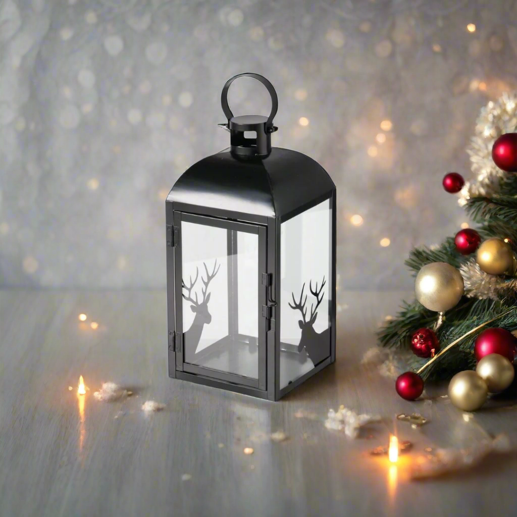 Black lantern with glass front featuring deer silhouettes on a white background