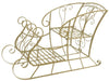 A gold-finished metal sleigh-shaped plant shelf with decorative scrollwork and three tiers, shown on a plain white background.